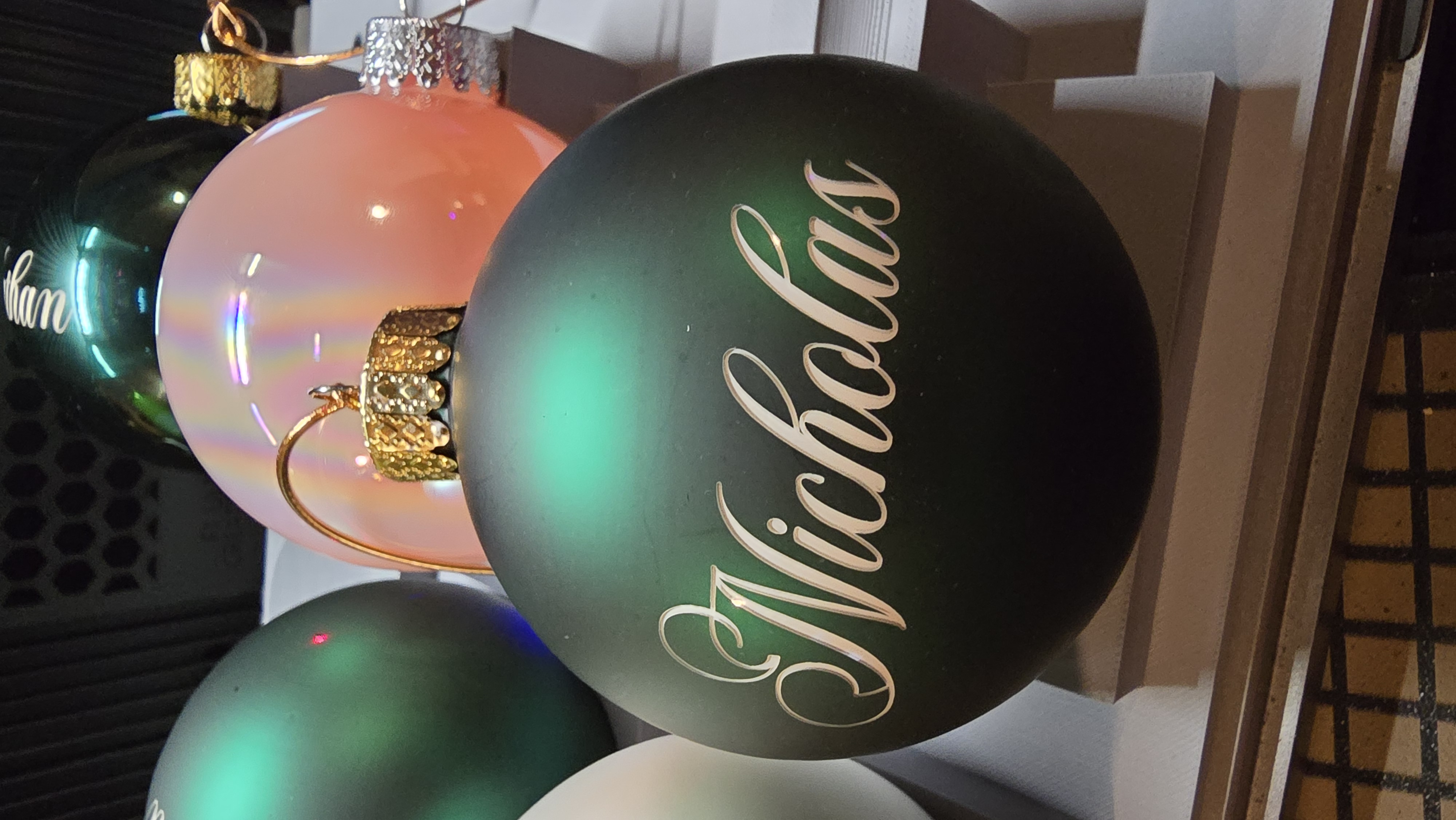 Green glass Christmas ornament engraved with the name Nicholas