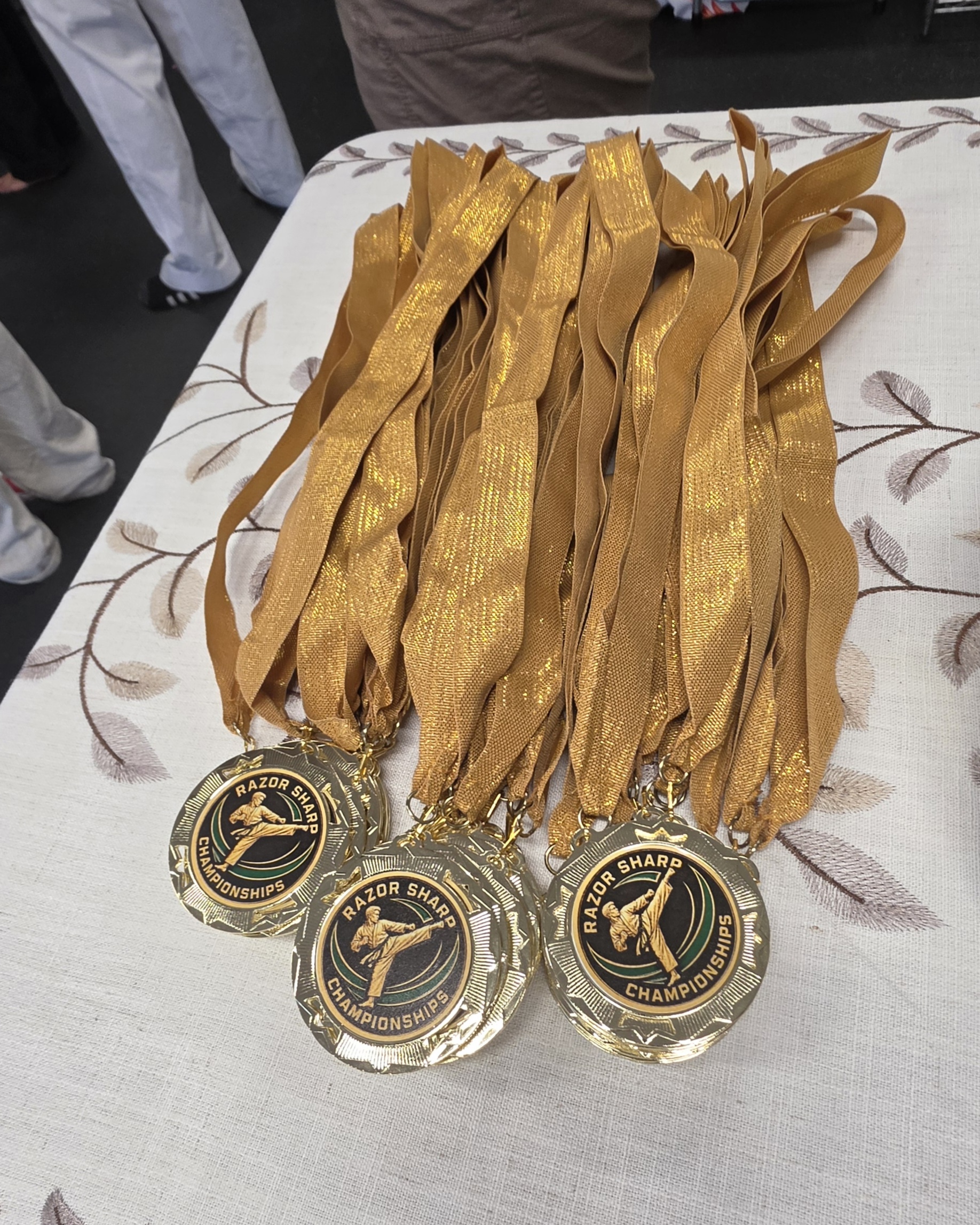 Completed Razor Sharp Taekwondo Championship medals with gold ribbons
