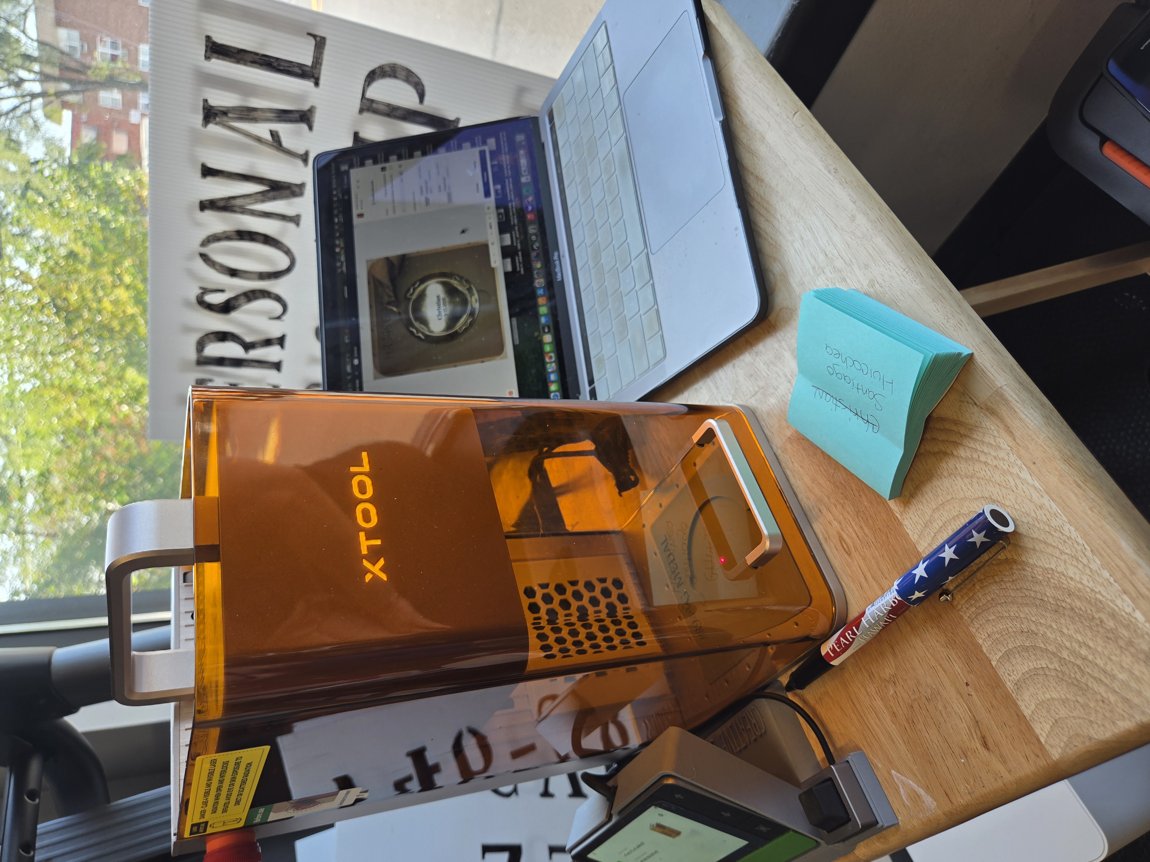 Orange xTool F2 laser and laptop at a live medal personalization station